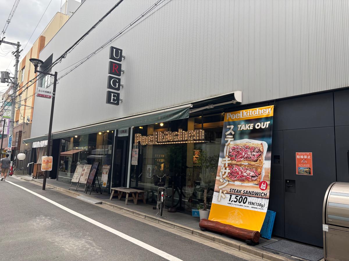 URGEの看板の下が入り口　店の前はスタッフ専用駐輪場